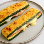 Cordon bleu de courgette croustillant farci au jambon et fromage fondu sur une assiette blanche