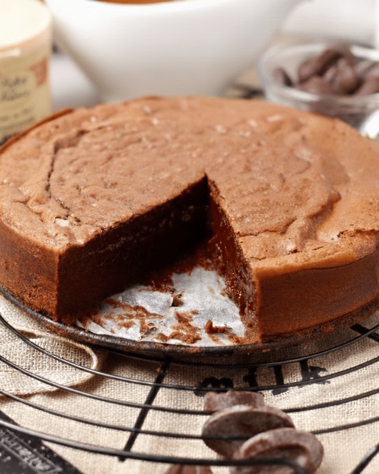 Fondant Baulois A close-up side view of a slice of chocolate fondant showing a dense, moist, and uniform chocolate interior with a thin, crispy top crust.