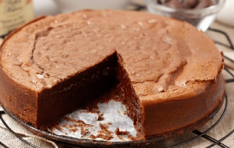 Fondant Baulois 1 Fondant Baulois A round, dark chocolate cake with a thin, delicately cracked meringue crust on top, featuring a signature red decorative seal in the center.
